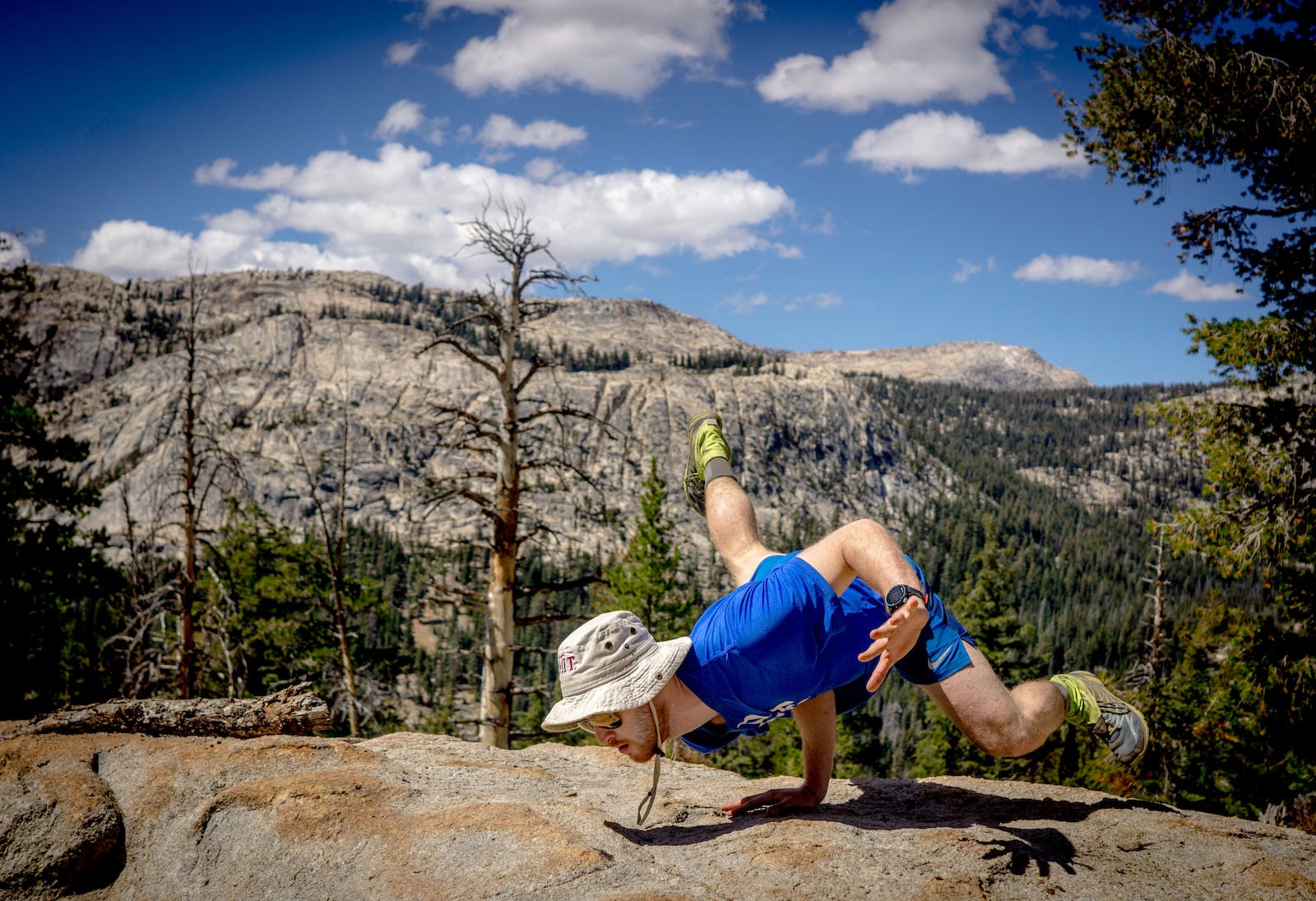 man doing hand stand on edge of cliff